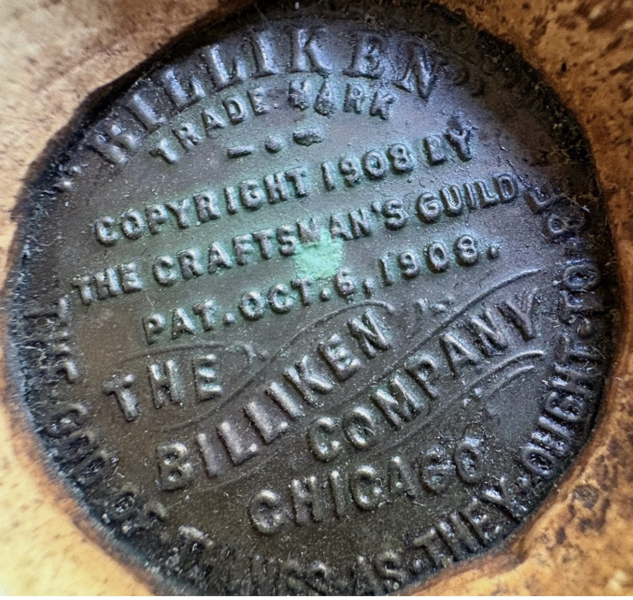 Token embedded in base of chalkware Billken figurine, 1908